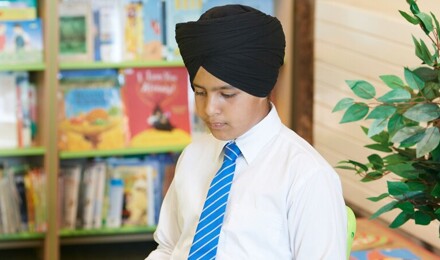 A child reading a book in the library area