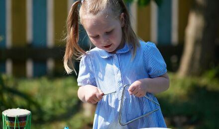 Child playing with musical instruments outside
