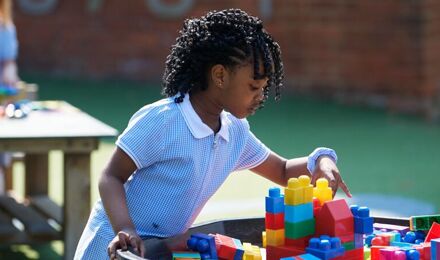 Child selecting building blocks outside