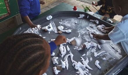 Nursery children playing with shaving foam