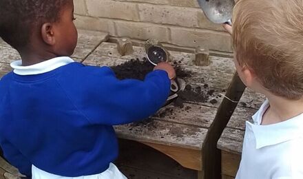 Nursery children playing in the mud kitchen